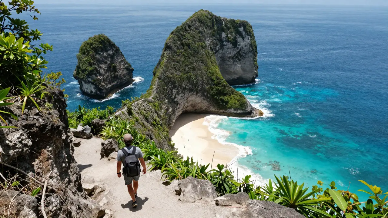 Pantai Kelingking di Nusa Penida dengan tebing berbentuk T-rex menjulang di atas laut biru, seorang traveler berjalan di jalan setapak.