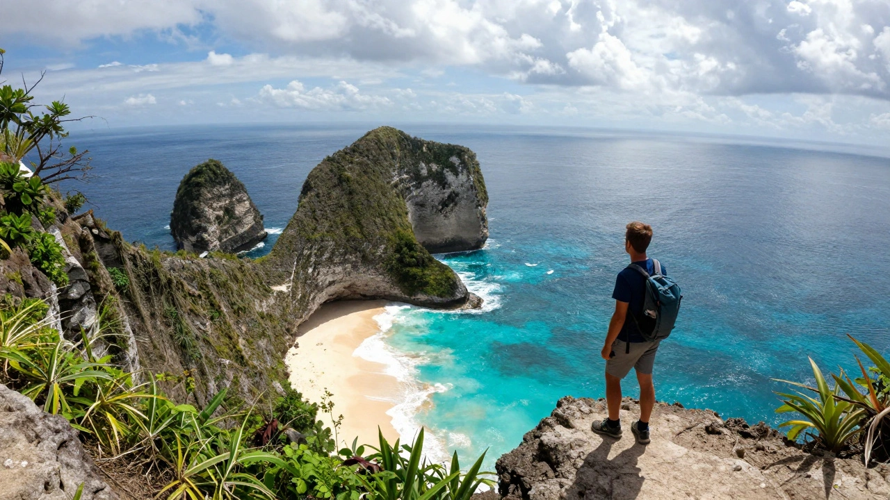 Pantai Kelingking di Nusa Penida, tebing berbentuk T-rex menghadap laut biru, seorang pendaki berdiri di tepi.